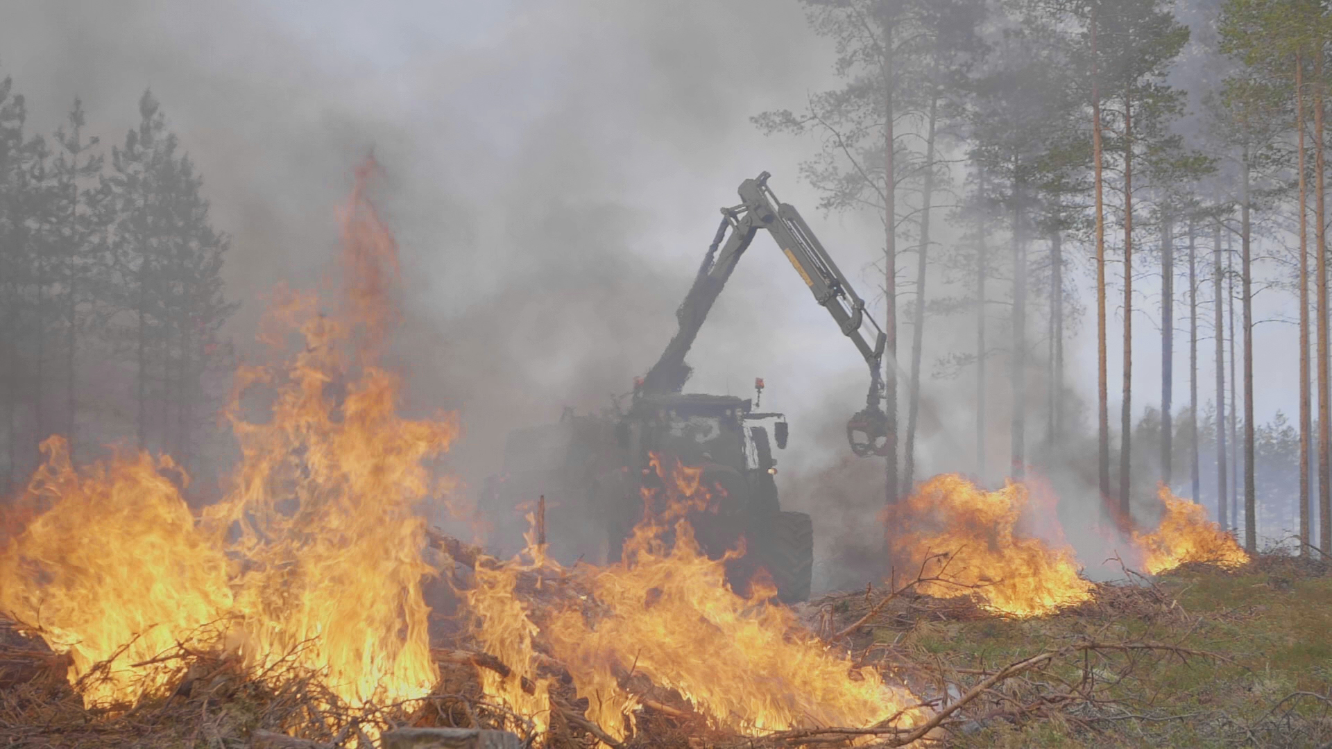 Kesla Hydrax operating in the middle of a forest fire surrounded by flames and smoke